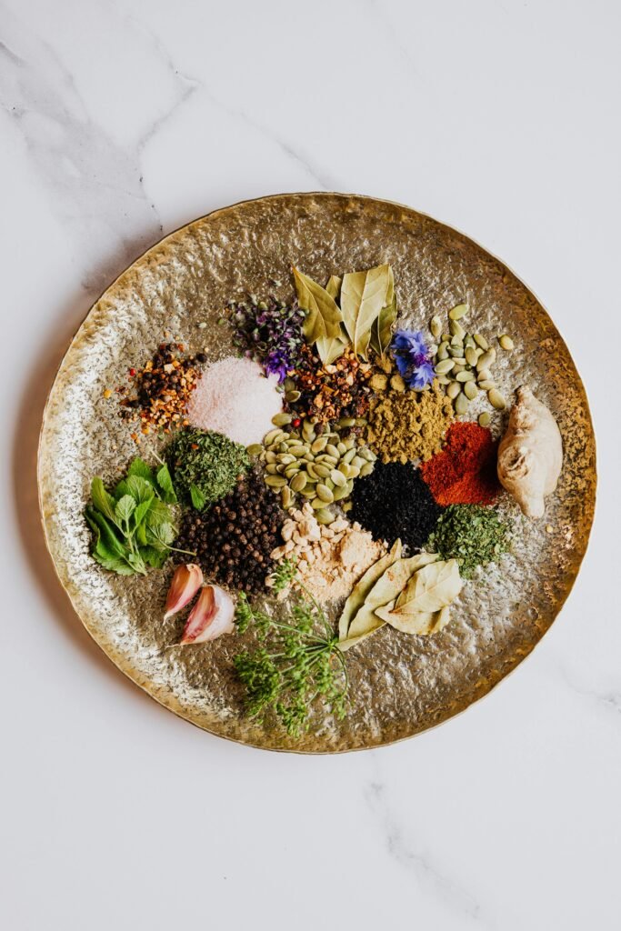 Vibrant spices and herbs artfully arranged on a textured round plate, showcasing a diverse culinary palette.