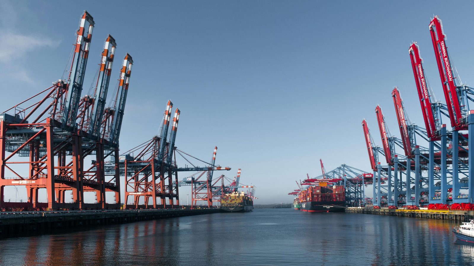 Panoramic view of Hamburg's bustling container terminal highlighting cranes and cargo ships.